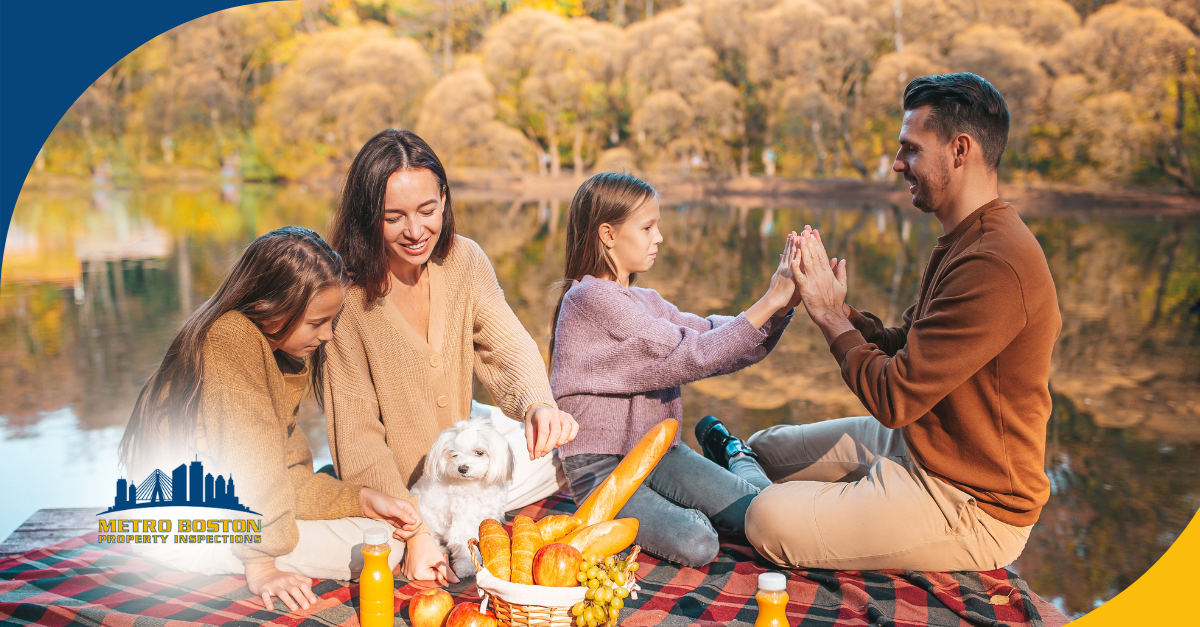 Family enjoying an outdoor picnic by the lake with their dog