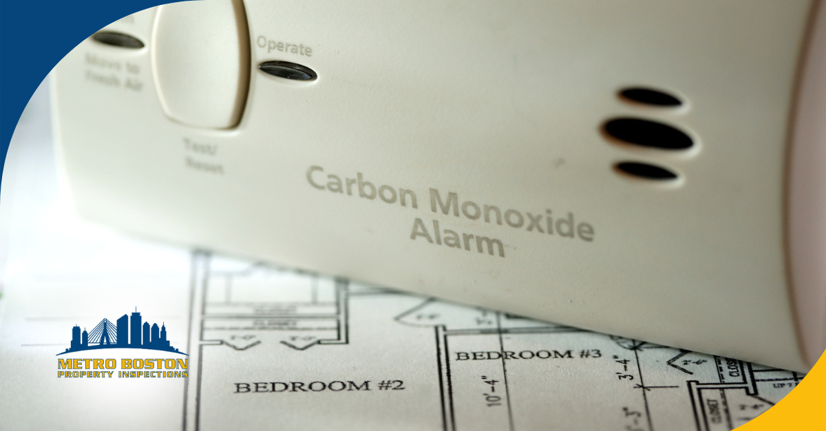 Close-up of a carbon monoxide alarm placed on home blueprints