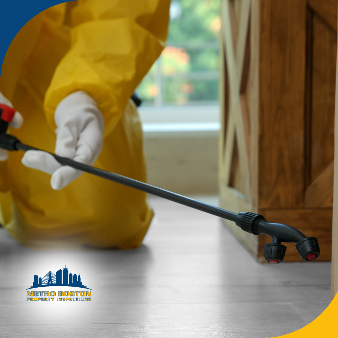 Pest control technician in yellow protective suit applying indoor treatment.