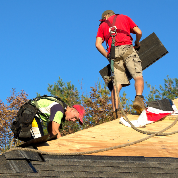 Roof inspectors working on a roof installation with safety gear and equipment.