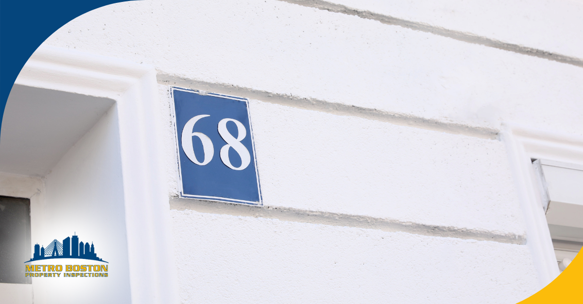 Blue house number plaque 68 on a white wall
