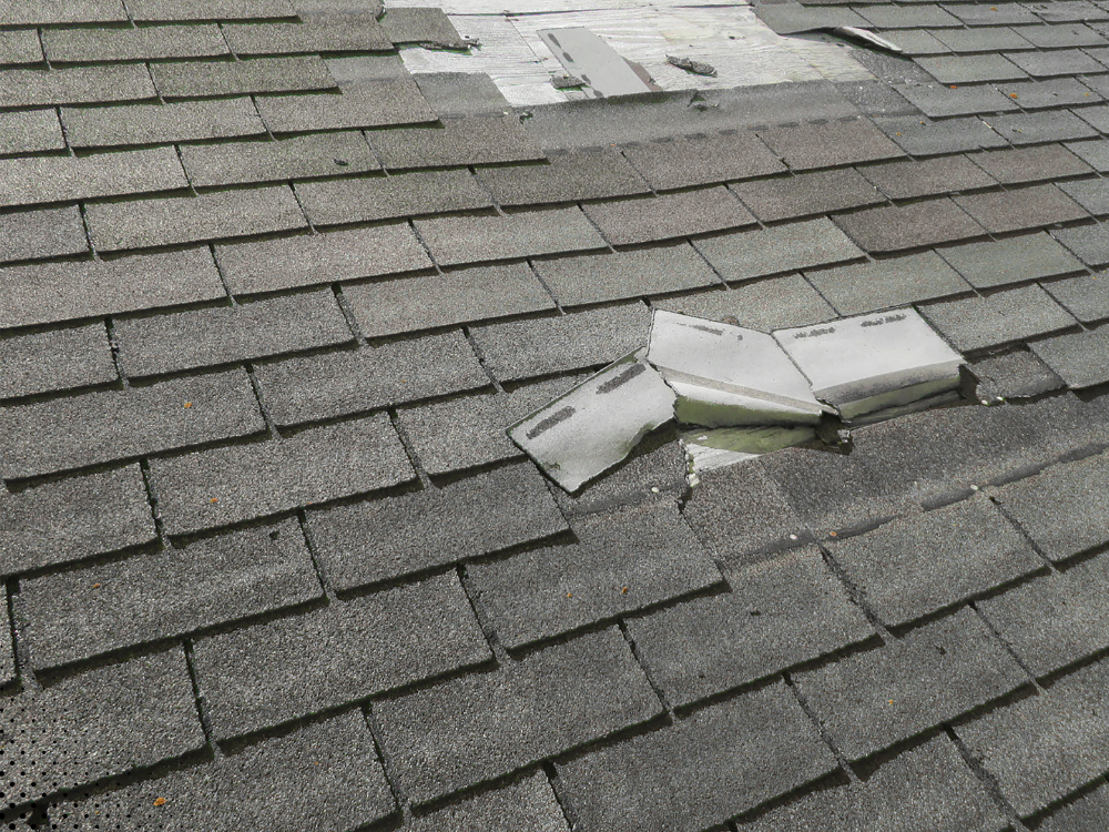 Broken roof flashing on asphalt shingles.